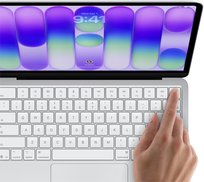 MacBook Neo, color plata, pantalla de inicio de sesión, dedo de una persona apoyado sobre el sensor Touch ID en la esquina superior derecha del teclado