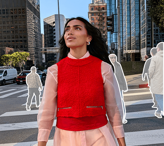Imagen de estilo de vida de una mujer mirando hacia la izquierda que representa la función Editor mágico, con siluetas de otras figuras en el fondo de una ubicación urbana.