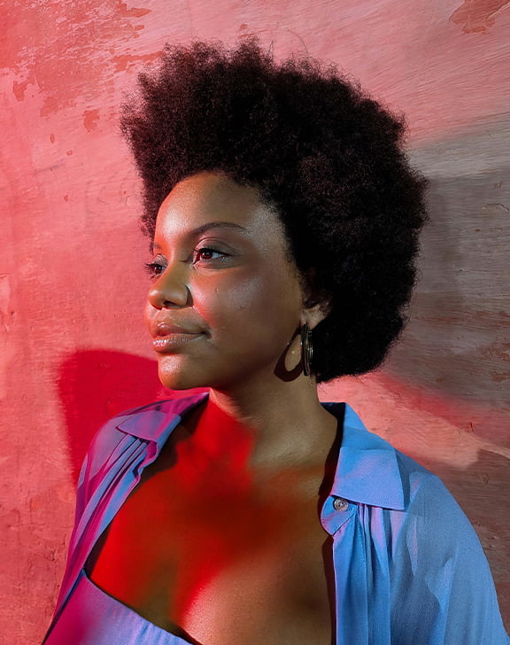Imagen de estilo de vida de una mujer frente a una pared con iluminación roja.