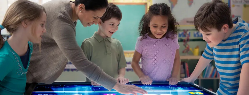 Profesora y alumnos mirando una pantalla 
