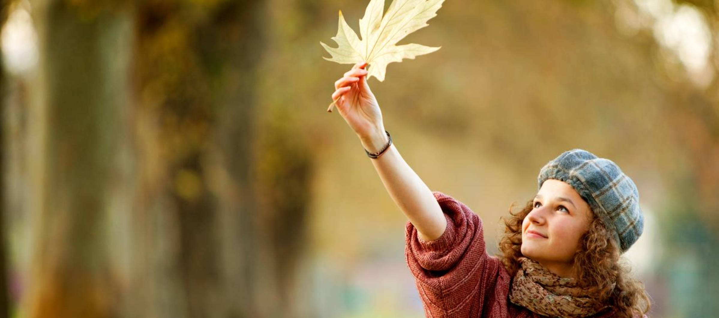 Chica_joven_jugando_con_una_hoja_caida_en_oto-o_en_el_parque