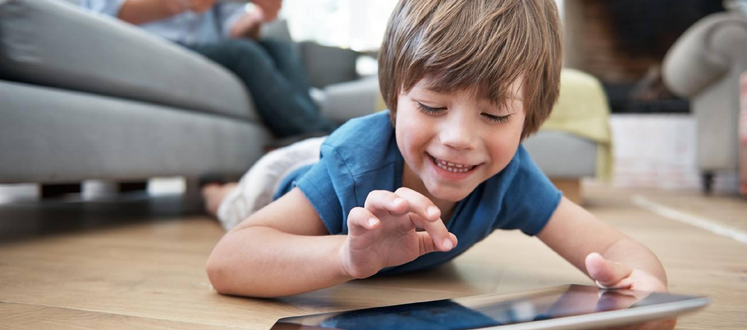 Ni-o_peque-o_tumbado_en_el_suelo_de_su_sal-n_usando_una_tablet
