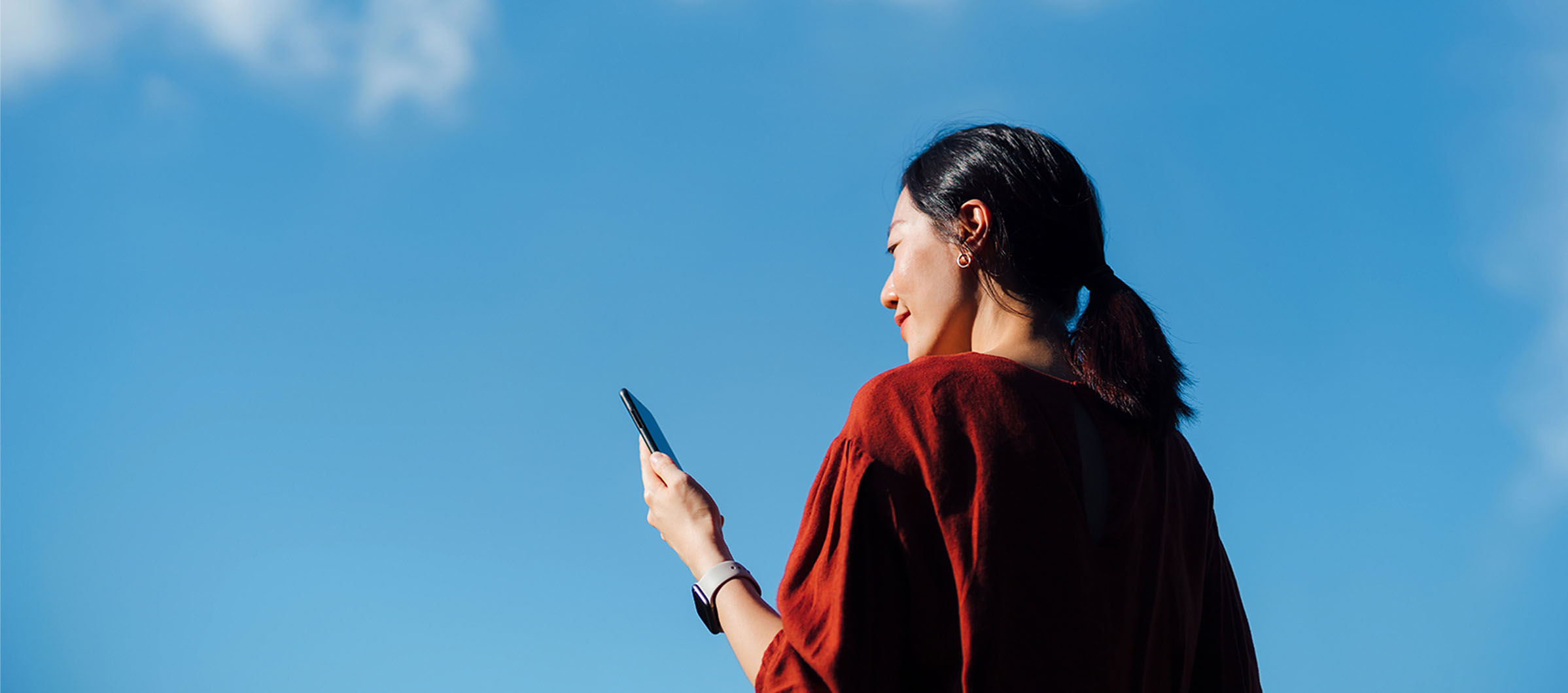 Mujer sentada mirando ropa en un smartphone  