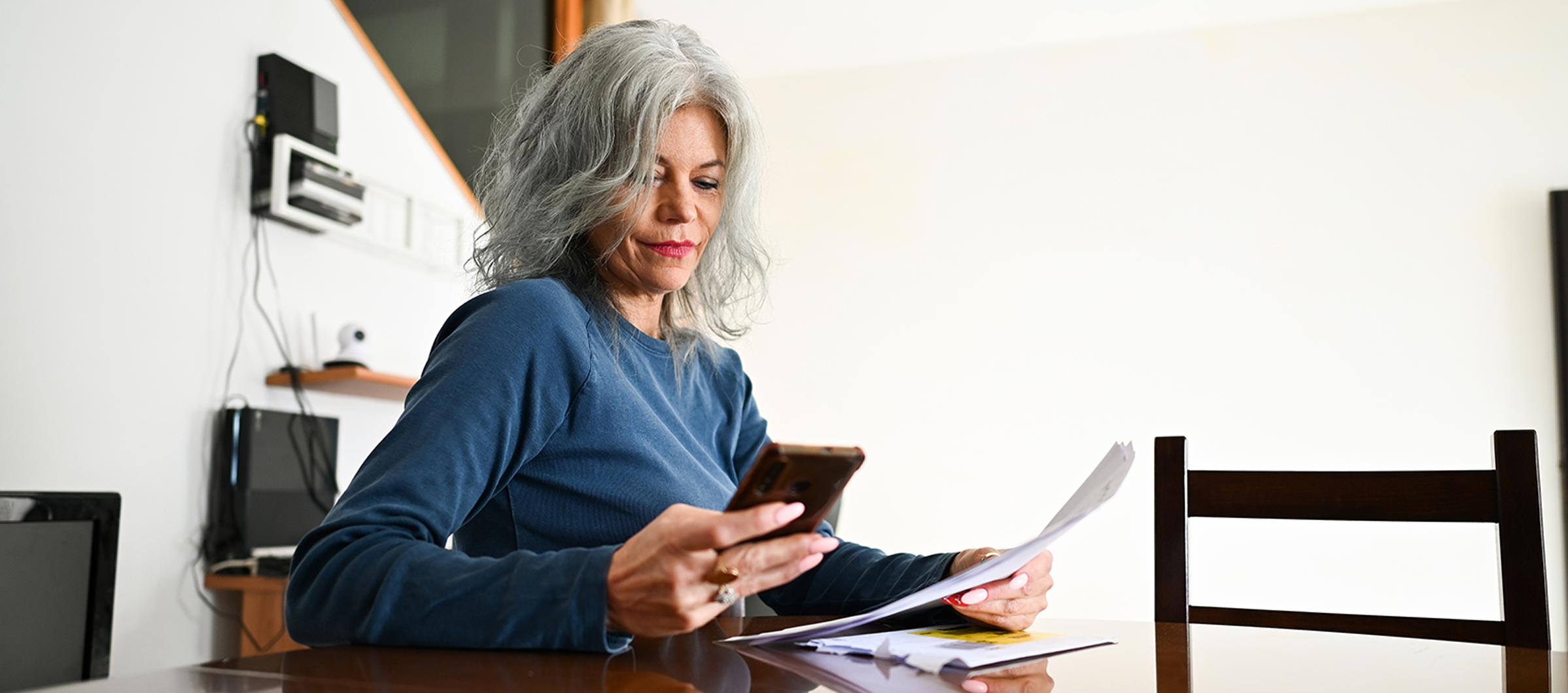 mujer%20con%20m%C3%B3vil%20y%20documentos%20en%20la%20mano