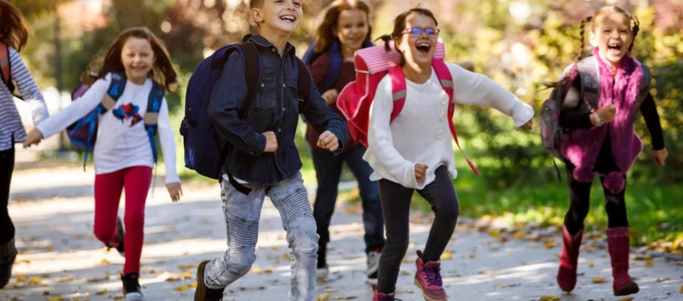 Niños con mochila corriendo